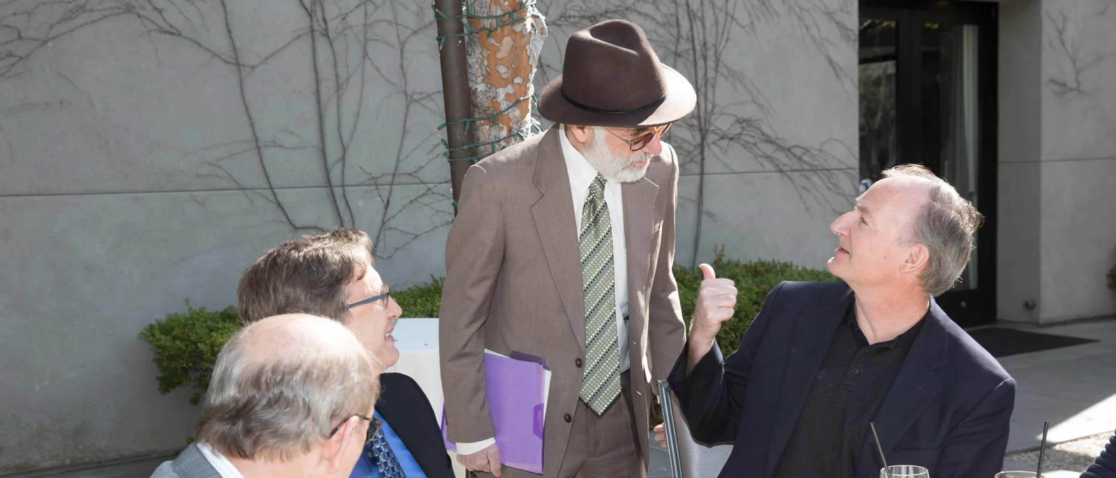 Dr. Hays sitting outside talking with other researchers outside at HSR symposium in 2017.